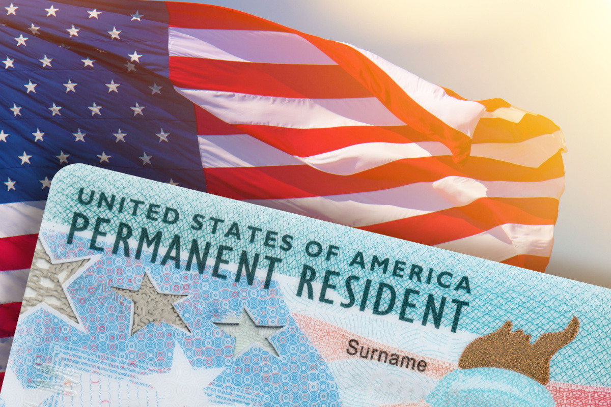 green card held in front of the American flag